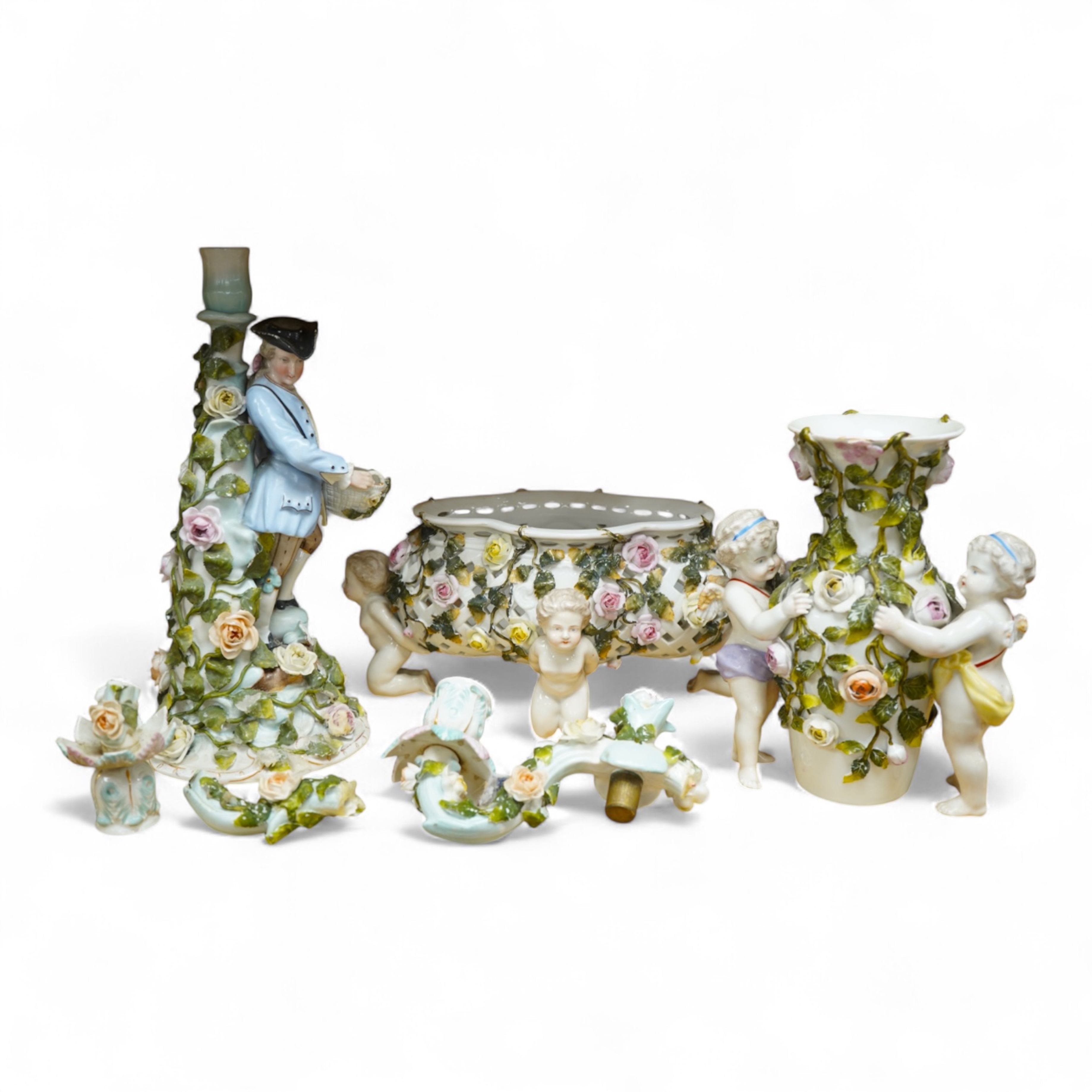 A German flower encrusted porcelain figural candelabrum, 30cm high, a cherub jardiniere and a cherub vase, all encrusted
